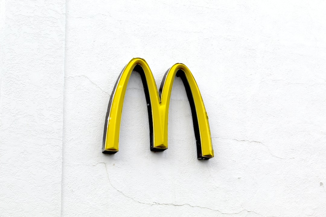 Sarı bir McDonald's "M" logosu, diğer adıyla Golden Arches, sade beyaz bir duvara monte edilmiş—WordPress Hosting'deki en iyi markalar gibi hemen tanınabilir.